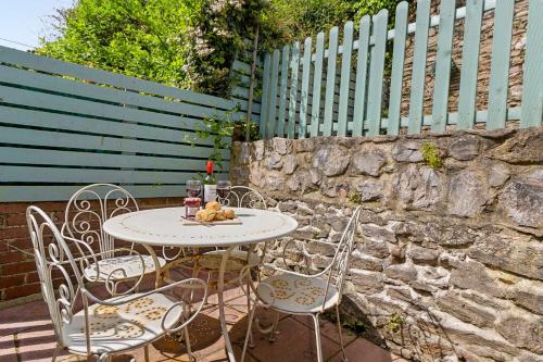 a table and chairs on a patio with a fence at Limpet Cottage - Beautiful Space & Close To Town in Brixham