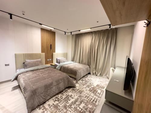 a bedroom with two beds and a flat screen tv at Private house Sheikh Zayed Egypt in 6th Of October