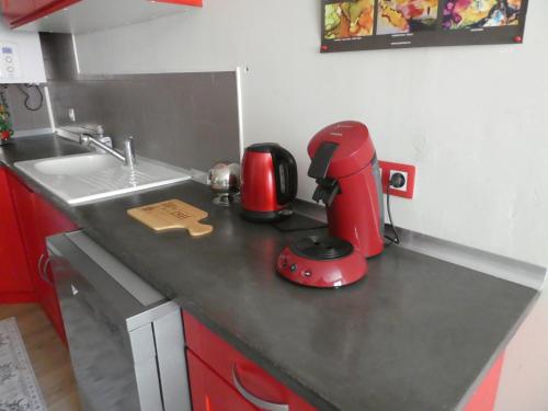 Une cuisine de simulation avec un appareil rouge sur un comptoir dans l'établissement La Courtine, centre historique Narbonne, à Narbonne