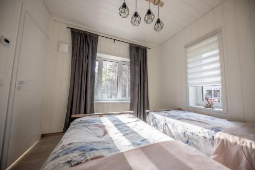 a bedroom with two beds and a window at Villa MARIKA plus in Alajõe