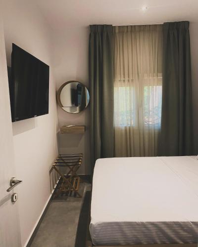 a hotel room with a bed and a television at Adams Apartments in Skala Rachoniou