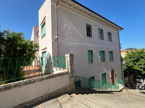a white building with a green fence around it at Bed and coffee Rooms Portoferraio in Portoferraio