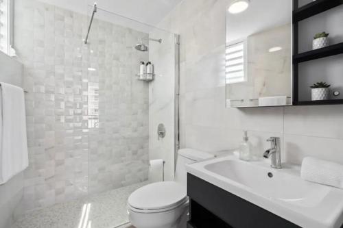 a white bathroom with a toilet and a sink at Apartamentos en excelente Zona Condado, San Juan, Puerto Rico in San Juan