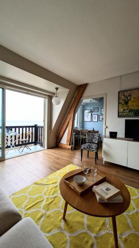 un salon avec un canapé et une table dans l'établissement L'Echandon, Superbe F2 vue mer accès plage immédiat, à Blonville-sur-Mer