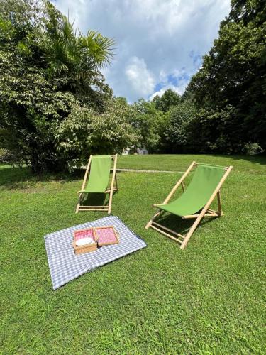two lawn chairs sitting on the grass in a field at Borgo del 1700 Le Scuderie - bilocale in Travedona
