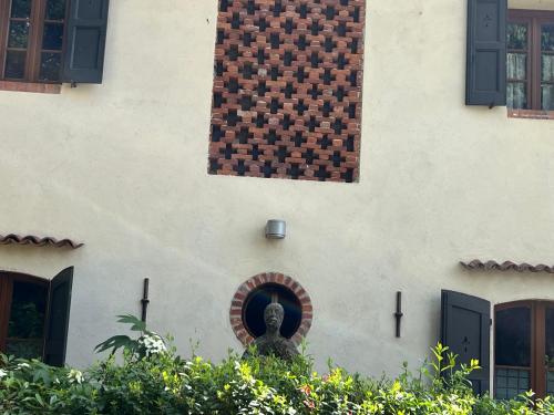 a statue in front of a building with a window at Borgo del 1700 Le Scuderie - bilocale in Travedona