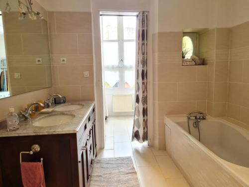 une salle de bain avec une baignoire et un lavabo et une baignoire dans l'établissement chez F&F, à Orléans