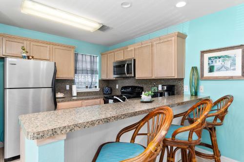 a kitchen with a refrigerator and two chairs at Little Get-Away By The Beach ,Moondancer in South Padre Island