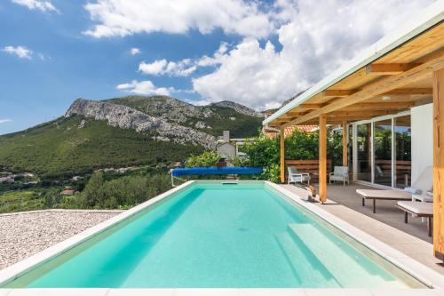 a swimming pool in a house with a mountain at Barefoot Summer House in Klis