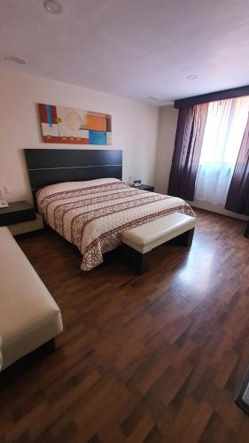 a bedroom with a bed and a wooden floor at Hotel Paraiso in Mexico City