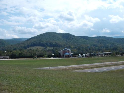 a road next to a field with a mountain in the background at Mountain Inn & Suites in Erwin