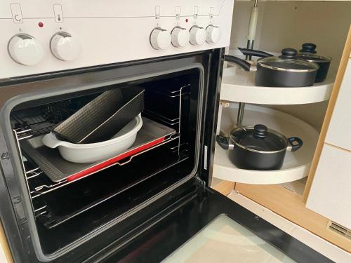 a kitchen with an oven with some utensils in it at Stilvolles Apartment mit Balkon, Küche & Parkplatz - Waldstetten Zentrum in Waldstetten