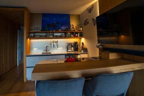 Una cocina con encimera, fregadero y sillas azules. en Apartmán Jasan Brčálník, en Železná Ruda