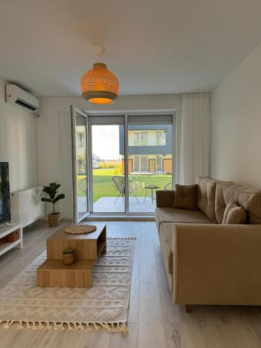 a living room with a couch and a table at Libertatii Gardens Poolside AIRPORT&THERME in Otopeni