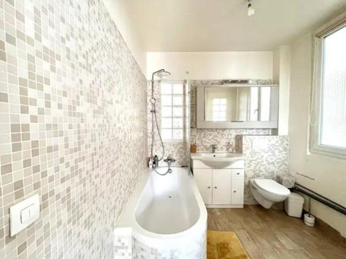 une salle de bain avec une baignoire, un lavabo et des toilettes dans l'établissement Bel Appartement 96m2 16eme, à Paris