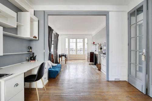 une cuisine avec des placards blancs et une salle à manger dans l'établissement Bel Appartement 96m2 16eme, à Paris