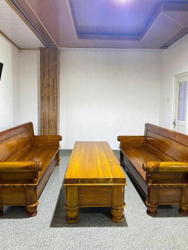 a room with two benches and a wooden table at Hotel Wijaya family 2 in Yogyakarta
