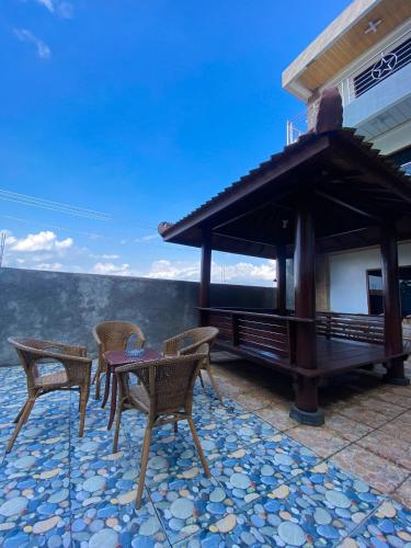 a patio with chairs and a table and a gazebo at Hotel Wijaya family 2 in Yogyakarta