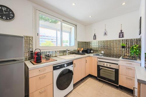 une cuisine avec une machine à laver et une fenêtre dans l'établissement Appartement Port Marchand, à Toulon