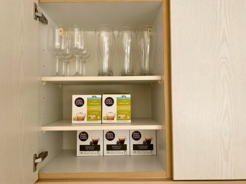 a cupboard with glasses and boxes in it at Stilvolles Apartment mit Balkon, Küche & Parkplatz - Waldstetten Zentrum in Waldstetten