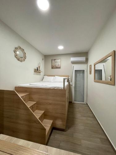 a bedroom with a bed and a mirror and a staircase at stefanidis apartments in Kalymnos