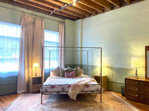 a bedroom with a bed with a metal canopy at Main Office Lofts Building - 4 lofts in Lynchburg