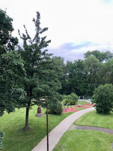 a park with a tree and a playground at Stilvolles Apartment mit Balkon, Küche & Parkplatz - Waldstetten Zentrum in Waldstetten