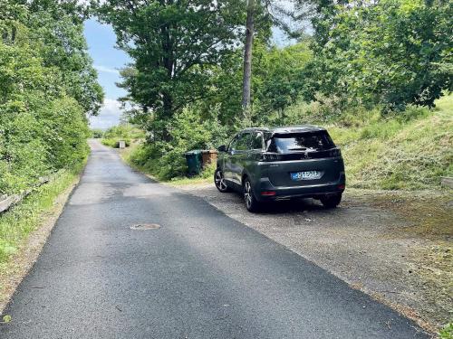 a green car parked on the side of a road at 4 star holiday home in Uddevalla in Uddevalla