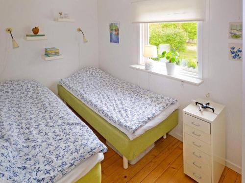two beds in a room with a window at Spacious holiday home for family-By Traum in Laholm