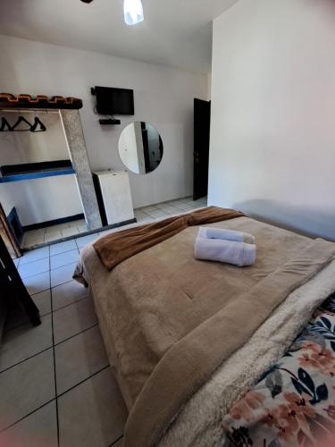 a bedroom with a large bed and a mirror at Pousada Luar de Penedo in Penedo