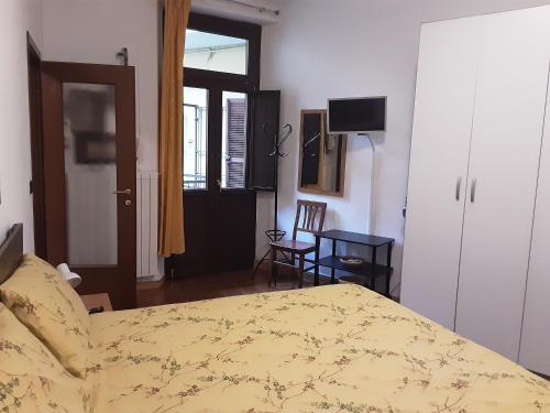 ein Schlafzimmer mit einem Bett und einem Tisch und einem Fernseher in der Unterkunft La Terrazzina, silenzioso, zona Piazza Gran Madre in Turin
