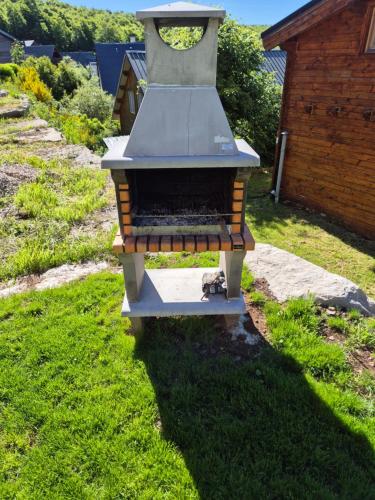 a barbecue grill sitting on the grass in a yard at AUBRAC Spa in Saint-Chély-dʼAubrac