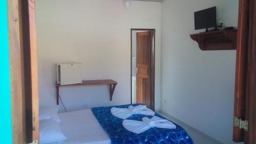 a small bedroom with a bed and a television at Sete Marias in Paraty