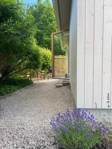 a garden with purple flowers next to a building at House by the ocean in Halmstad