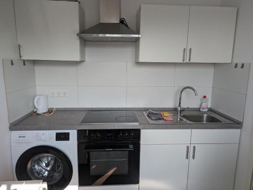 a kitchen with a washing machine and a sink at Ferienwohnung 301 am Kasinopark in Georgsmarienhütte