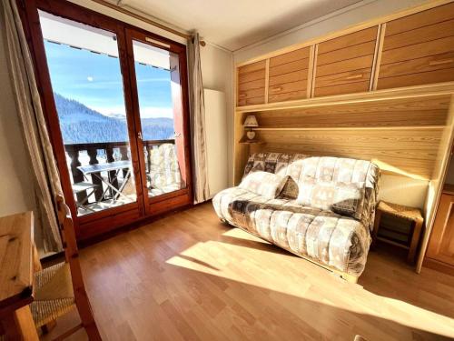 un salon avec un canapé et une grande fenêtre dans l'établissement Résidence L'ancolie - Studio au pied des pistes - 1450 m MAE-2764, à Notre-Dame-de-Bellecombe