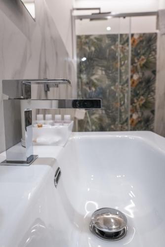 a white sink with a silver faucet in a bathroom at La Peonia B&B in Ragusa