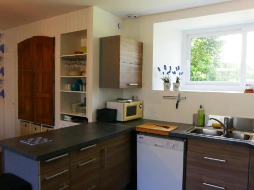 une cuisine avec un évier et un micro-ondes dans l'établissement kerispern, à Trégunc