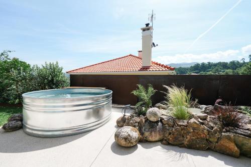a large metal tub sitting on a patio with a garden at ALTAMENTE - Alojamento Local in Viana do Castelo