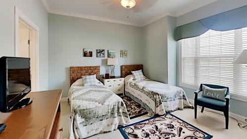 a bedroom with two beds and a desk and a tv at Retreat to Coastal Elegance: Golf and Beach Access in Pawleys Island