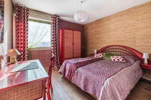 - une chambre avec un lit rouge et une table dans l'établissement Le Célestine Très joli T2 centre ville -Garage, à Saint-Étienne