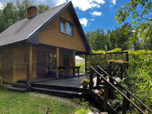 a small cabin with a wooden porch and a deck at Pirts māja Lilijas in Baldone