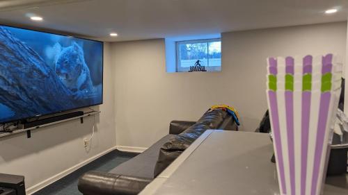 a living room with a couch and a large screen tv at Spacious&Gracious- 5BR Fam-Friendly near I95&Shops in Fairfield