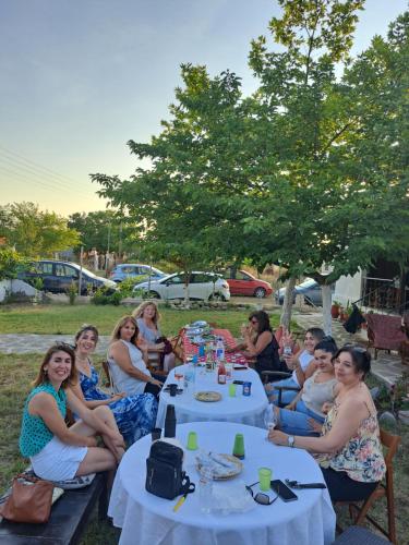 a group of people sitting at tables in the grass at Μονοκατοικία Kathrin in Nea Kalikratia