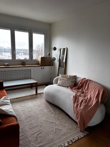 un salon avec un canapé et deux fenêtres dans l'établissement Magnifique 3 pièces à Aubervilliers, à Aubervilliers