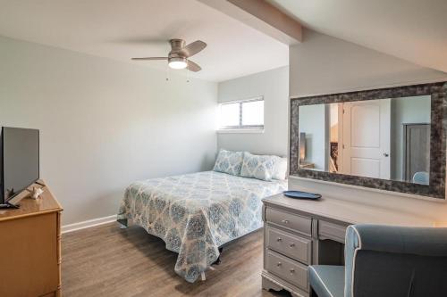 a bedroom with a bed and a dresser with a mirror at Serene Lakeview Retreat 3BR Villa Beach Access in Pawleys Island