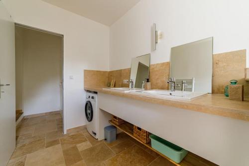 une salle de bain avec deux lavabos et une machine à laver dans l'établissement Rez-de-villa avec espace arboré privatif, à Sainte-Maxime