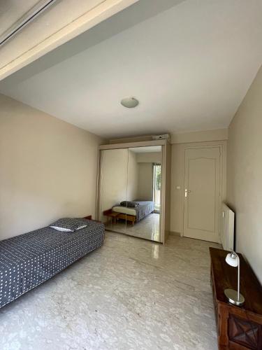 une chambre avec deux lits et un miroir dans l'établissement GuestRoom - Chambre d'hôte, au Cannet