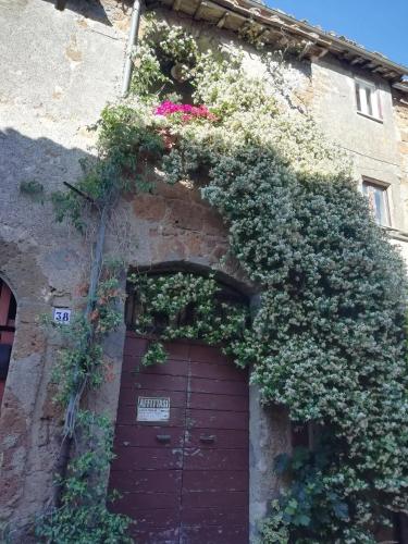 a brick building with a brown door with flowers at Charming House in Barbarano Romano with Terrace and Fireplace in Barbarano Romano