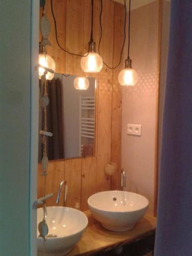 La salle de bains est pourvue de 2 lavabos, d'un miroir et de lumières. dans l'établissement Logement indépendant, à Colmar